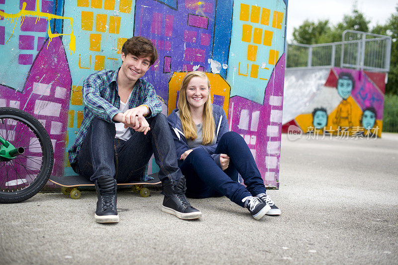 青少年情侣在滑板公园
