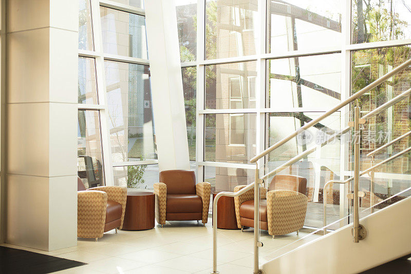 建筑风格:现代办公大堂。玻璃，钢制楼梯，窗户。椅子。