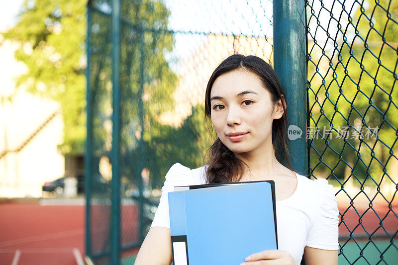 女学生在铁链围栏外