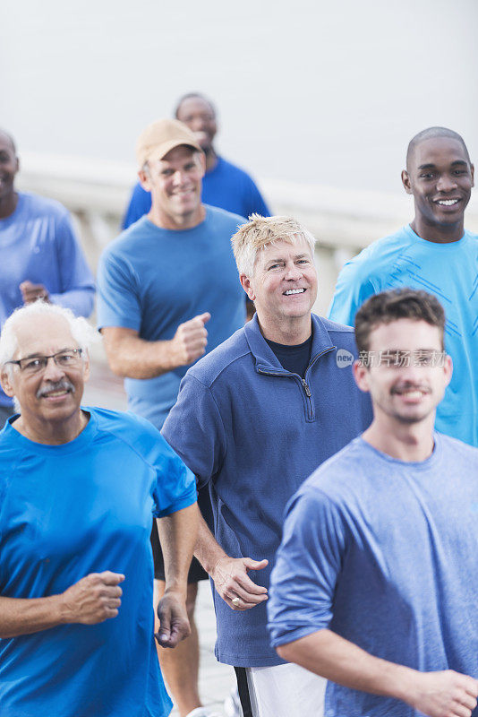 一群穿着蓝色衬衫的多种族男子在跑步