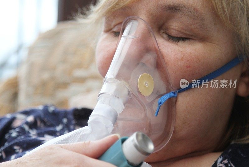 女性患者使用氧气面罩或呼吸机