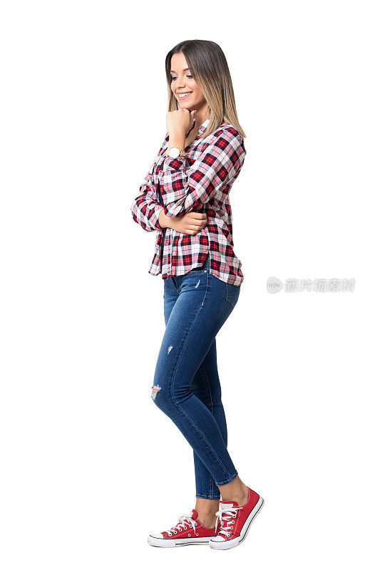 华丽的街头风格的女人穿着牛仔裤，格子衬衫和运动鞋