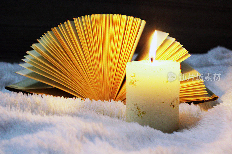在烛光下看书。