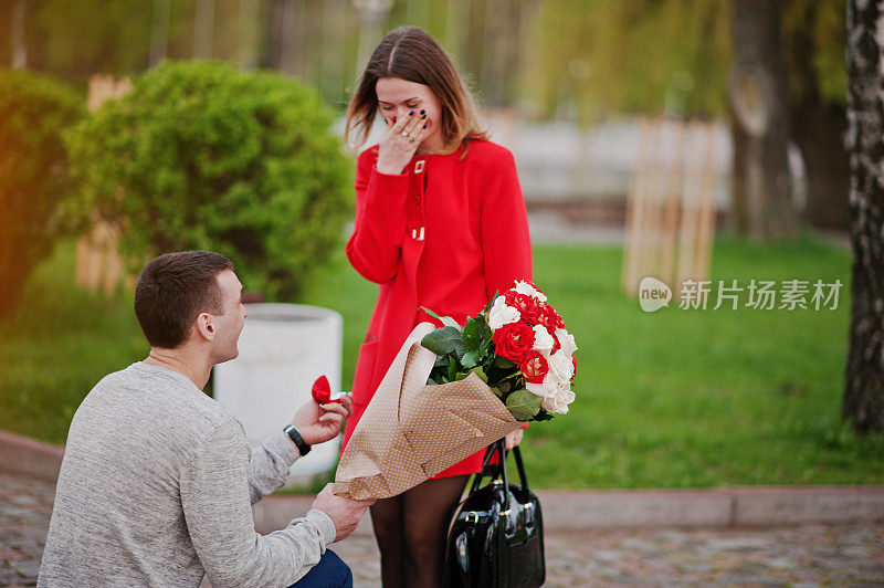 求婚。一个男人带着鲜花跪着，给他的女朋友送订婚戒指