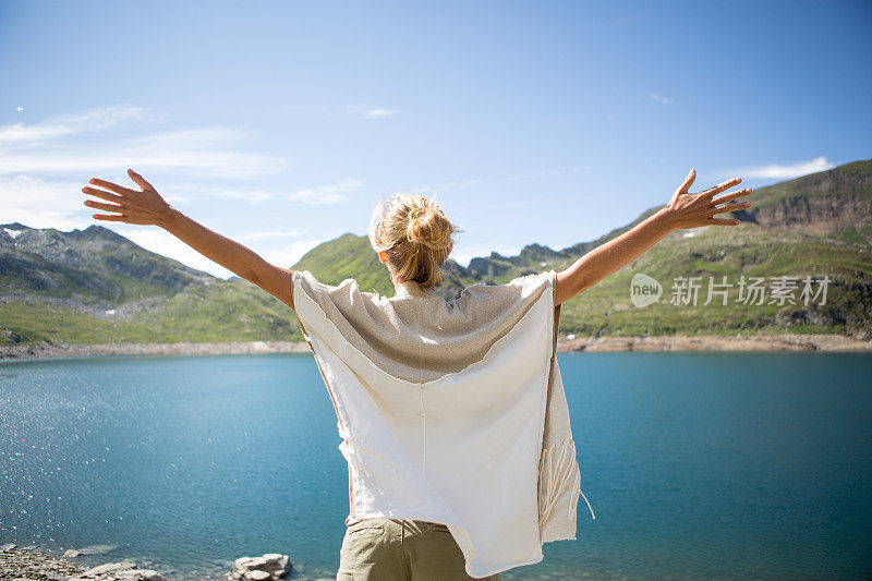 年轻美丽的女人向大自然张开双臂――夏天