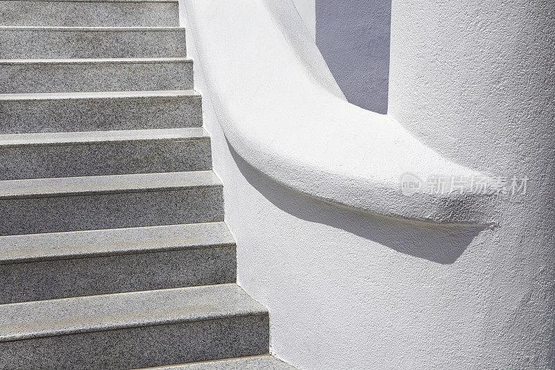 楼梯与浅灰色花岗岩台阶和白色灰泥墙