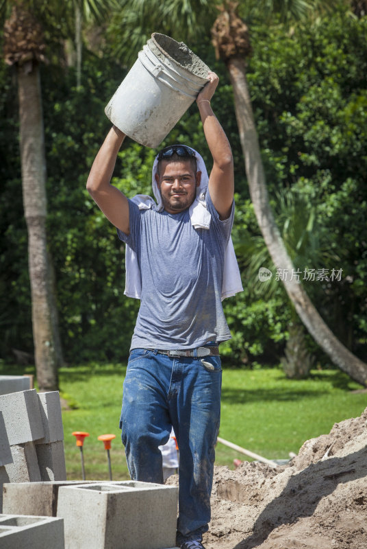 西班牙建筑工人搬运水泥桶