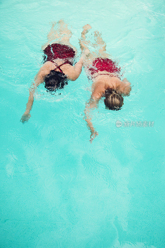 成熟的母亲和成年的女儿两代花样游泳选手。