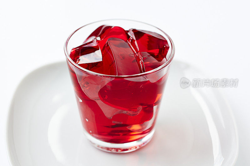红色的果冻块装在玻璃杯里