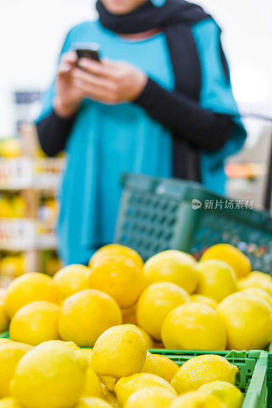 在超市里用智能手机的女人