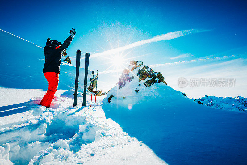 滑雪者在斜坡上举起双手