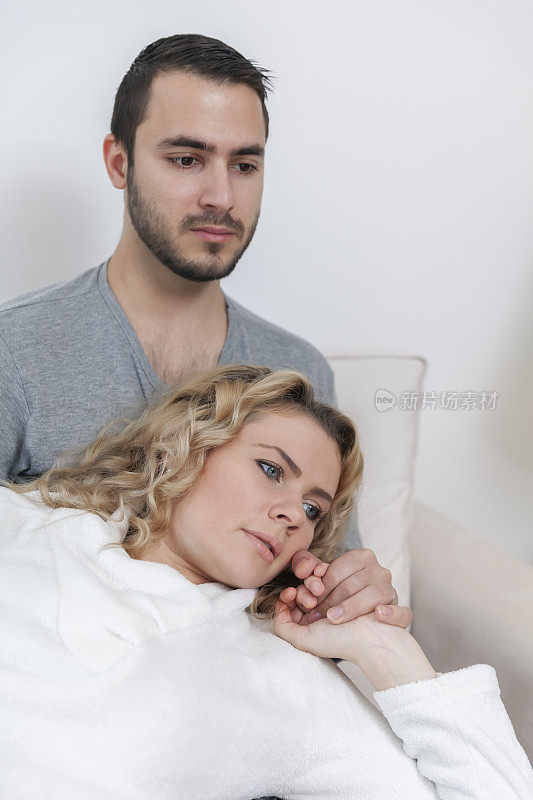 一个女人躺在他男友的腿上，握着他的手