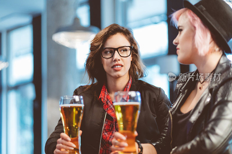 两个年轻女人在酒吧喝啤酒