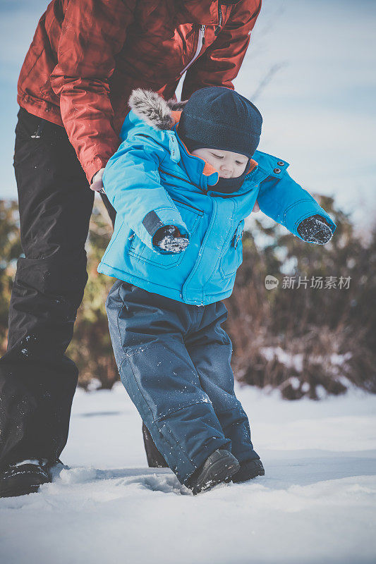 和妈妈一起学在雪地里走路的宝宝