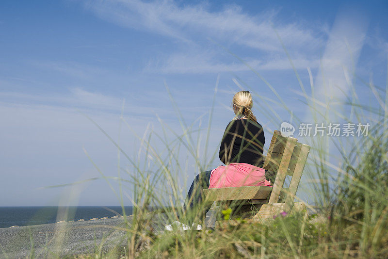 坐在海边木凳上的女人