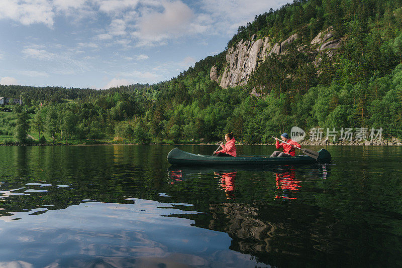 一对夫妇在挪威的湖上划独木舟