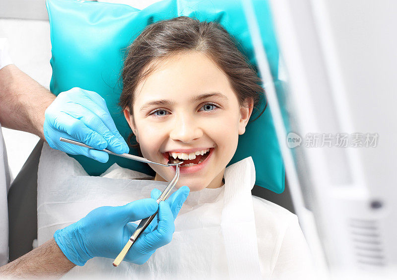 牙医，坐在牙科椅上的孩子。