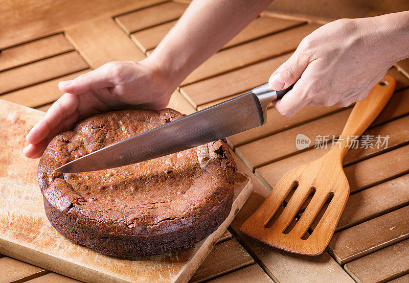 手握刀，切新鲜出炉的布朗尼蛋糕