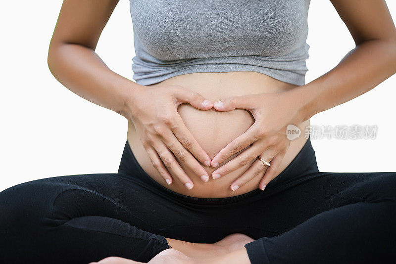 一名孕妇双手放在孕肚上做成心形