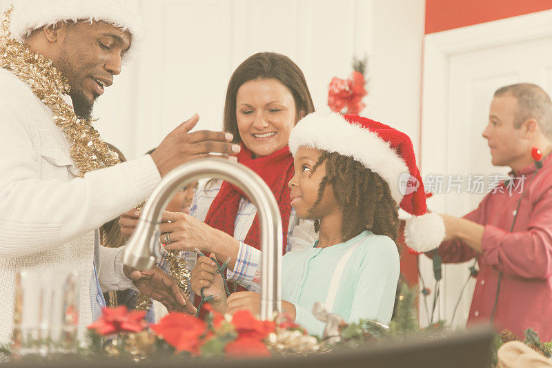 多民族家庭在家庭厨房为圣诞节装饰。