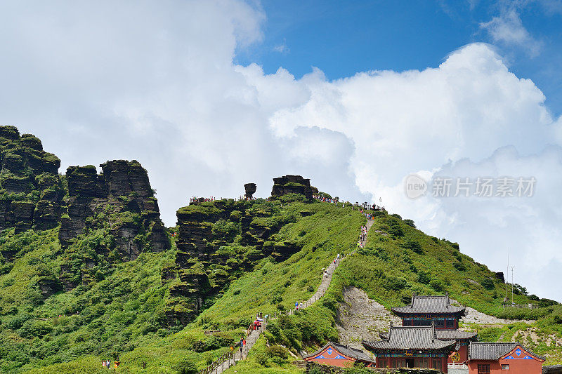 在中国西南陡峭的山上爬山的游客