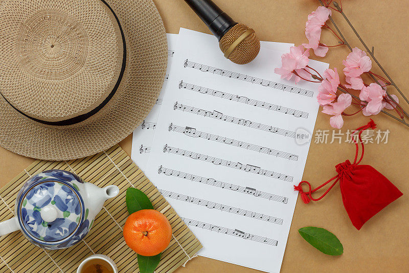 俯视中国和农历新年和乐谱的概念背景。写有假日必需品的便条。各种物品在棕色木制的家庭办公室办公桌的背景。