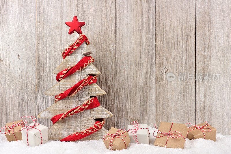 木制圣诞树与红色花环和礼物的木材