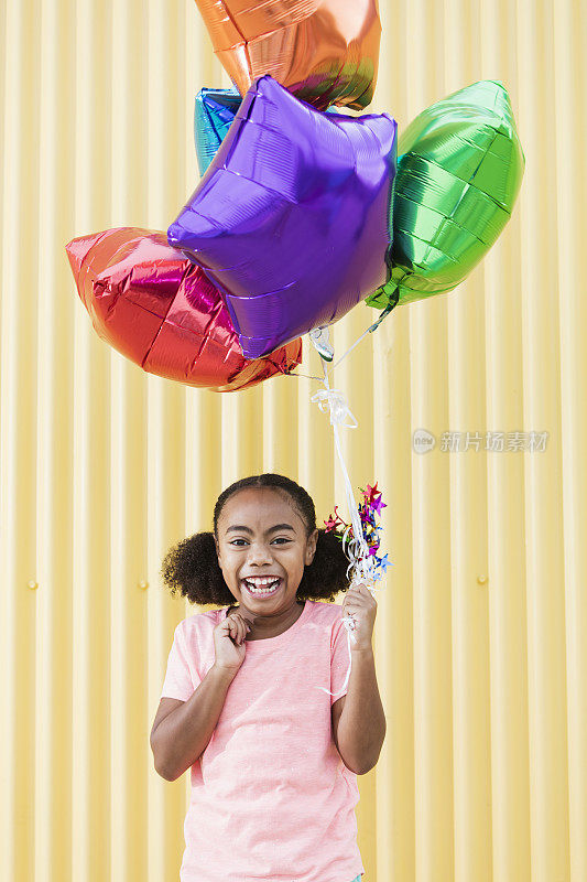 混血女孩拿着一堆氦气球