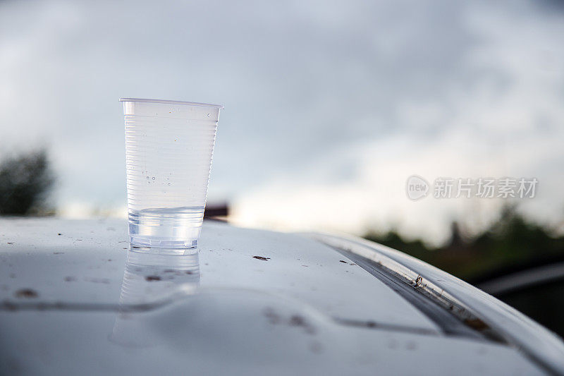 塑料杯装了半杯水浇在汽车上。