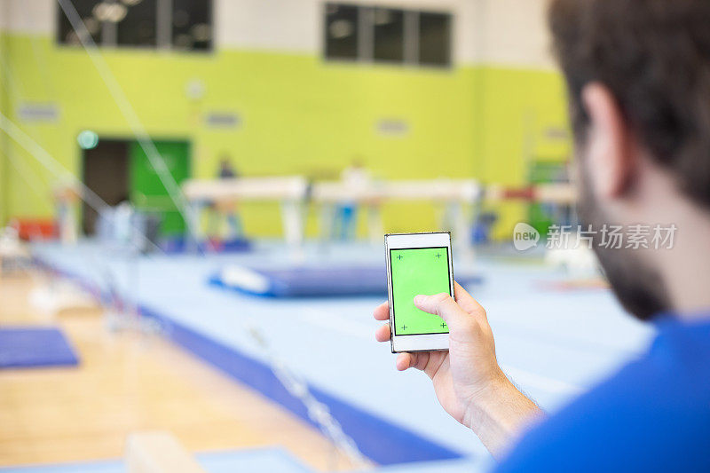 体操运动员在训练间歇使用绿屏手机