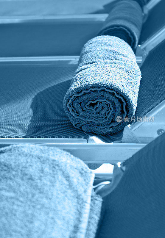 卷好的毛巾放在日光浴床上
