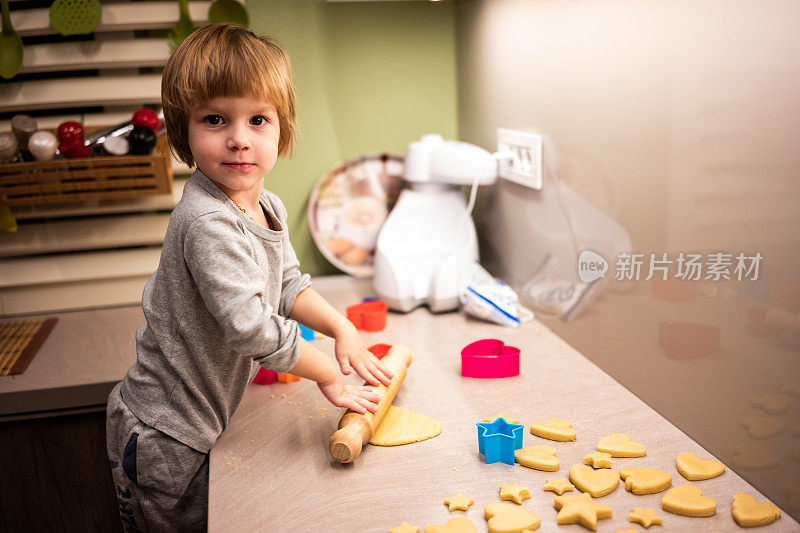 可爱的小面包师在厨房做饼干。