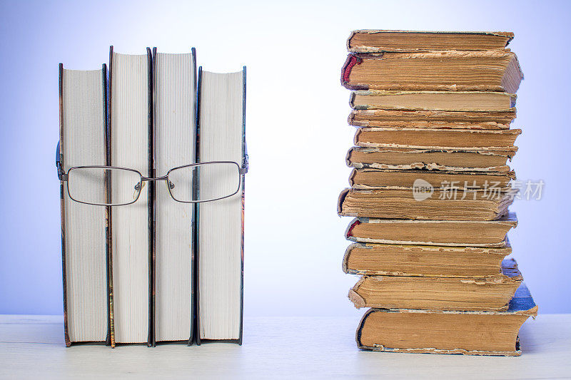 人脸由一些书籍制成，配上眼镜，堆满了破旧的旧书。阅读的概念。