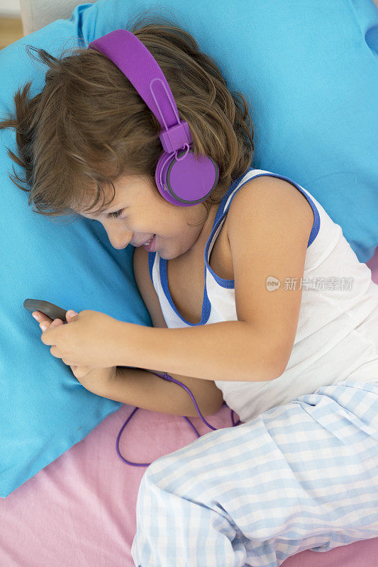 可爱的小男孩一边听音乐一边放松。