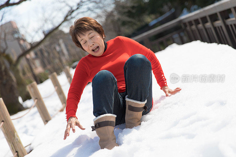 老妇人跌倒在雪中