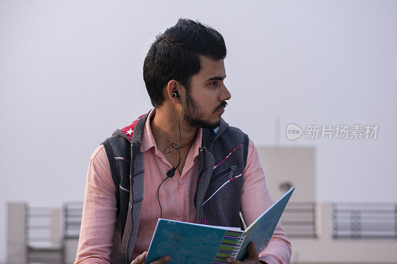 一个印度年轻人边听音乐边看书