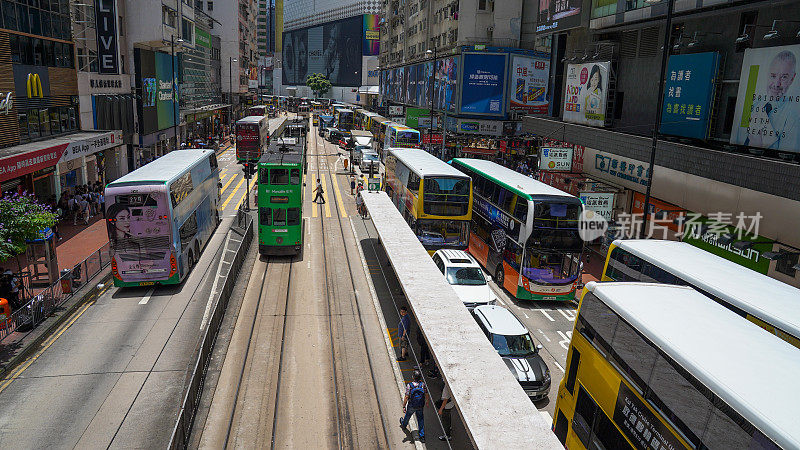 人们走过铜锣湾轩尼诗道，在中环道购物，在香港的法玛斯广场乘电车和火车旅行
