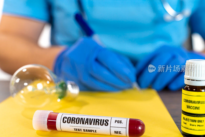 医生在黄色纸上写着COVID-19血液样本试管，特写