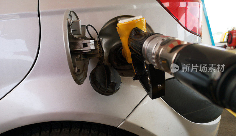 在气泵上抽气。特写的人泵汽油燃料在汽车在加油站。
