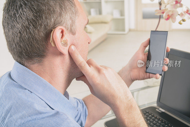 听力受损的人用笔记本电脑和手机工作