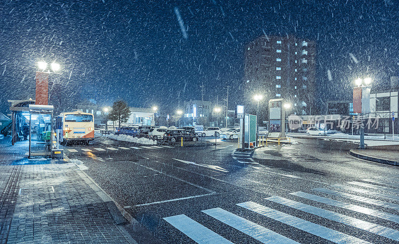 日本，山形，夜晚天空湛蓝的城市正在下雪。