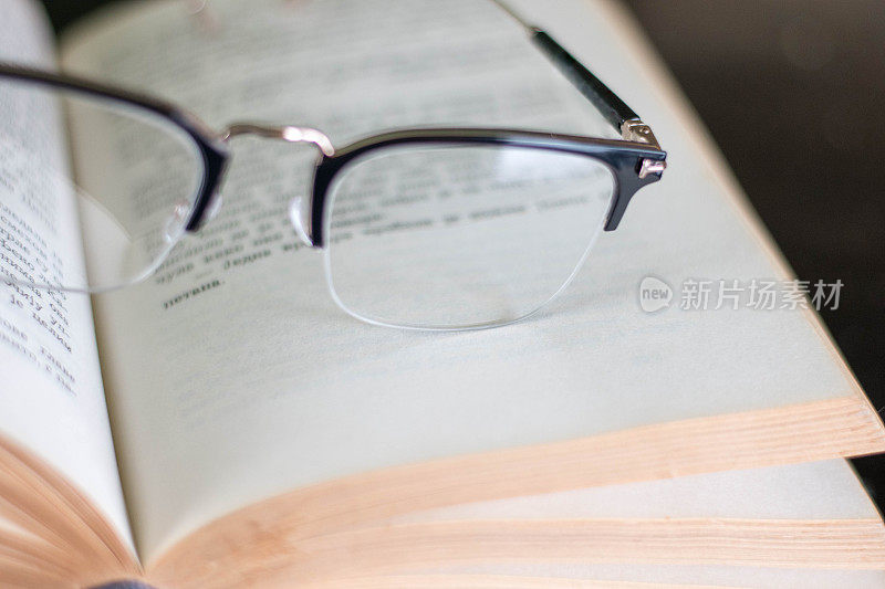 桌子上有一副眼镜和一本书。