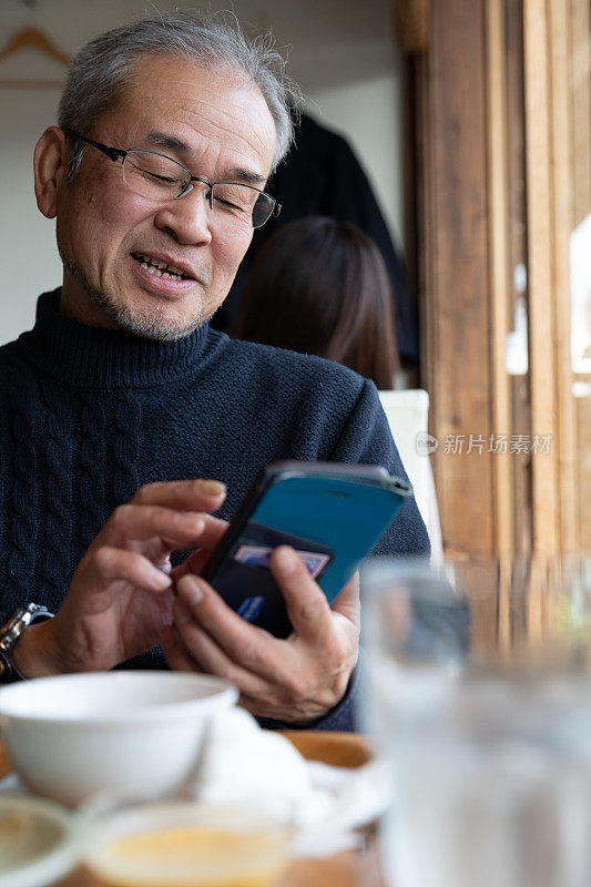 日本男子饭后使用智能手机