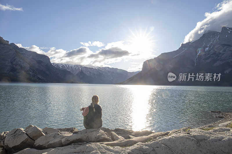 早晨，女人在湖边喝着浓咖啡放松