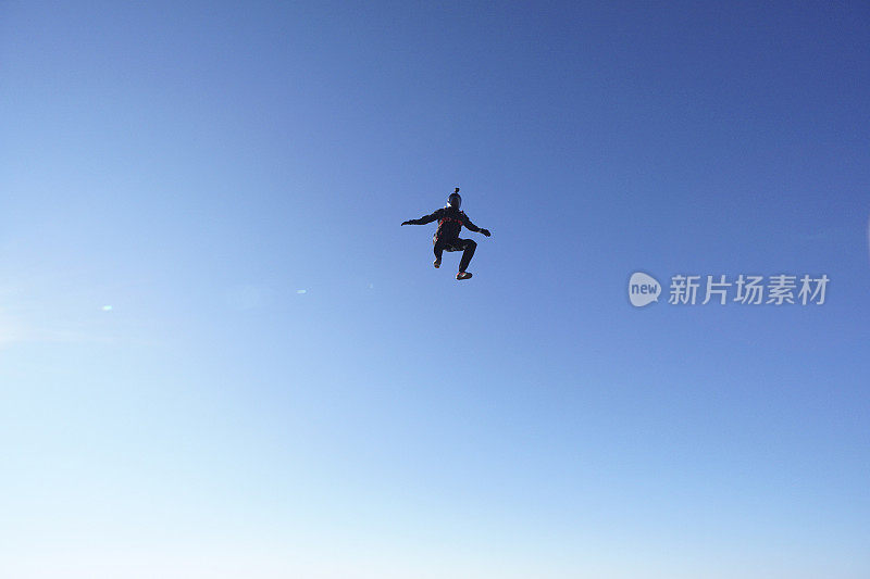 跳伞者从晴朗的天空坠落，空中飞行