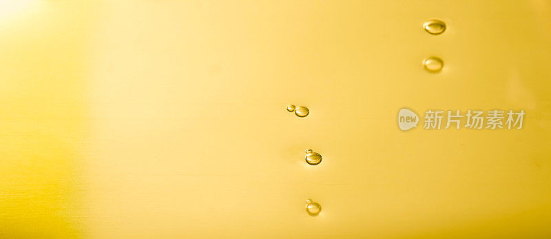液体黄金滴和波纹，抽象的背景