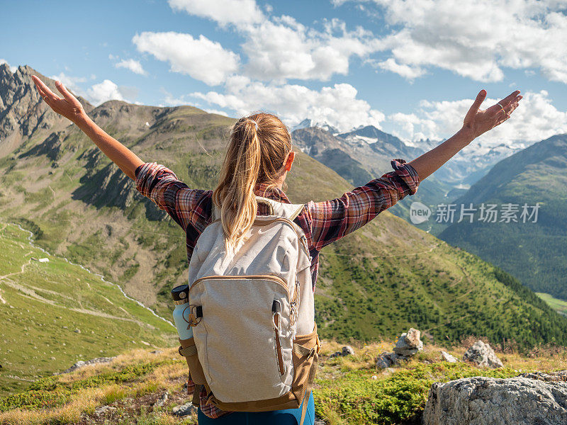 山上的年轻女子伸开双臂