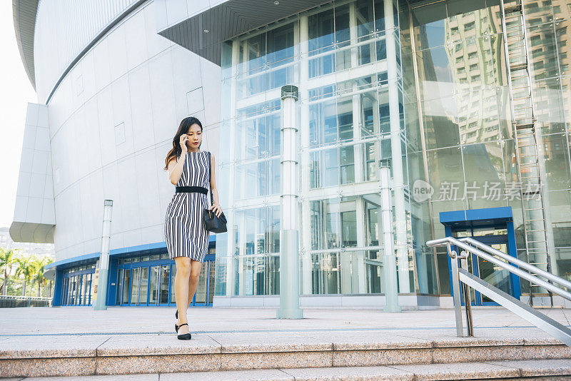 忙碌的女商人在城市里使用智能手机