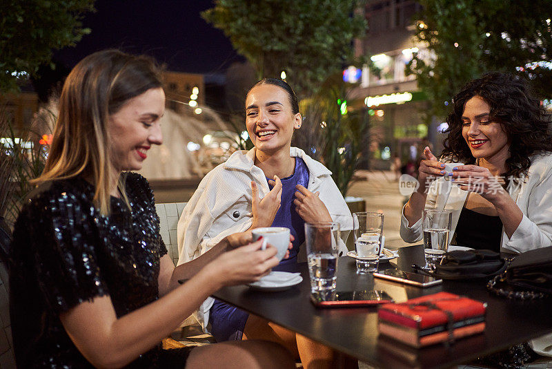 无忧无虑的年轻女性享受咖啡在咖啡馆晚上