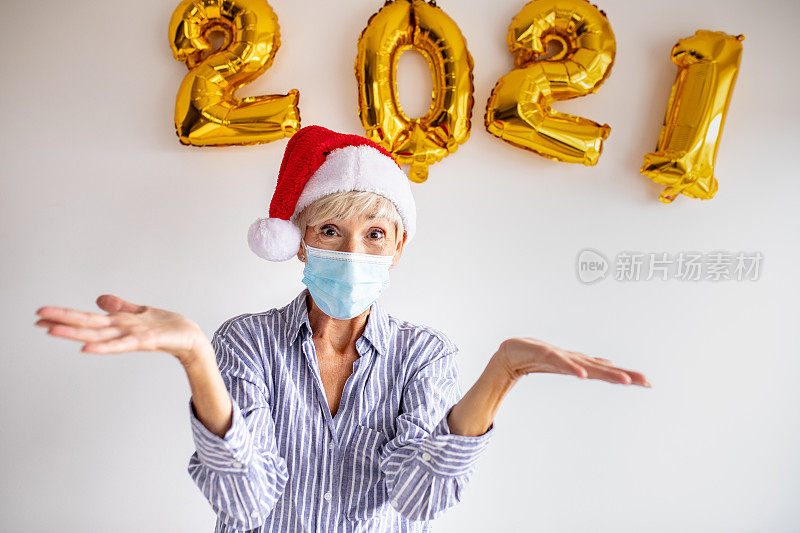 工作室拍摄的戴着面具庆祝2021年新年的高级女性